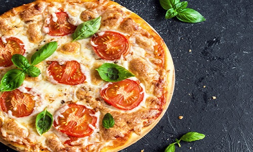 Pizza Margherita on black stone background, top view. Pizza Margarita with Tomatoes, Basil and Mozzarella Cheese close up.